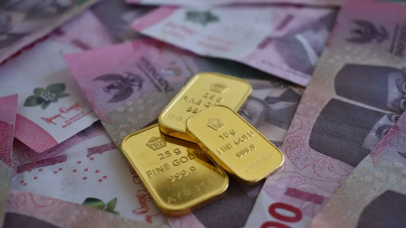 One kilogram cast gold bars stamped 999.9 stacked on a weighing table inside a refinery vault, with an assayer recording weights